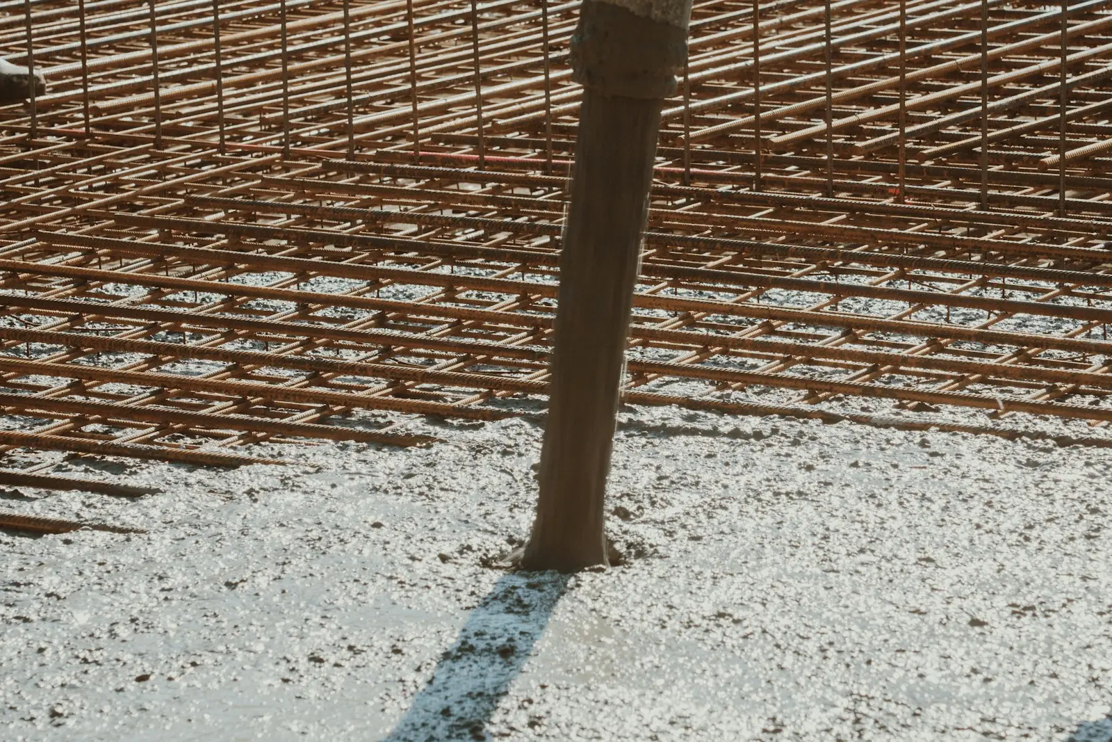 Malha de aço da armação sobre a base de concreto, em canteiro de obra