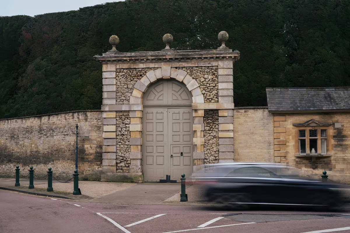 Portal de pedra de uma propriedade, com um carro passando em movimento