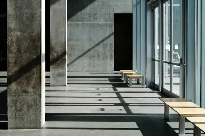 Galeria de concreto atravessada por luz e sombra