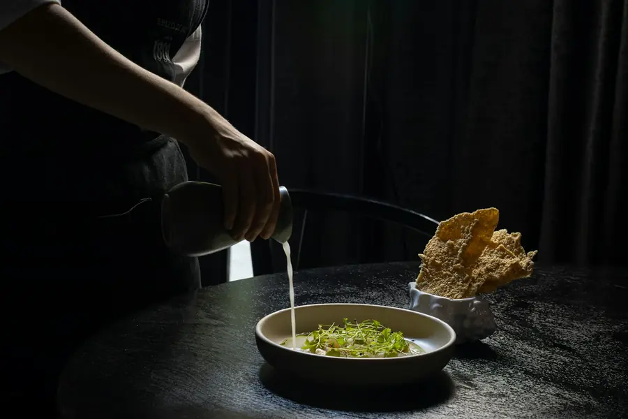 Chef finalizando um prato à mesa