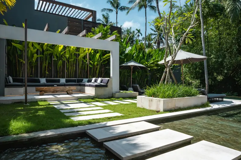 Jardim tropical com pérgola e espelho d'água
